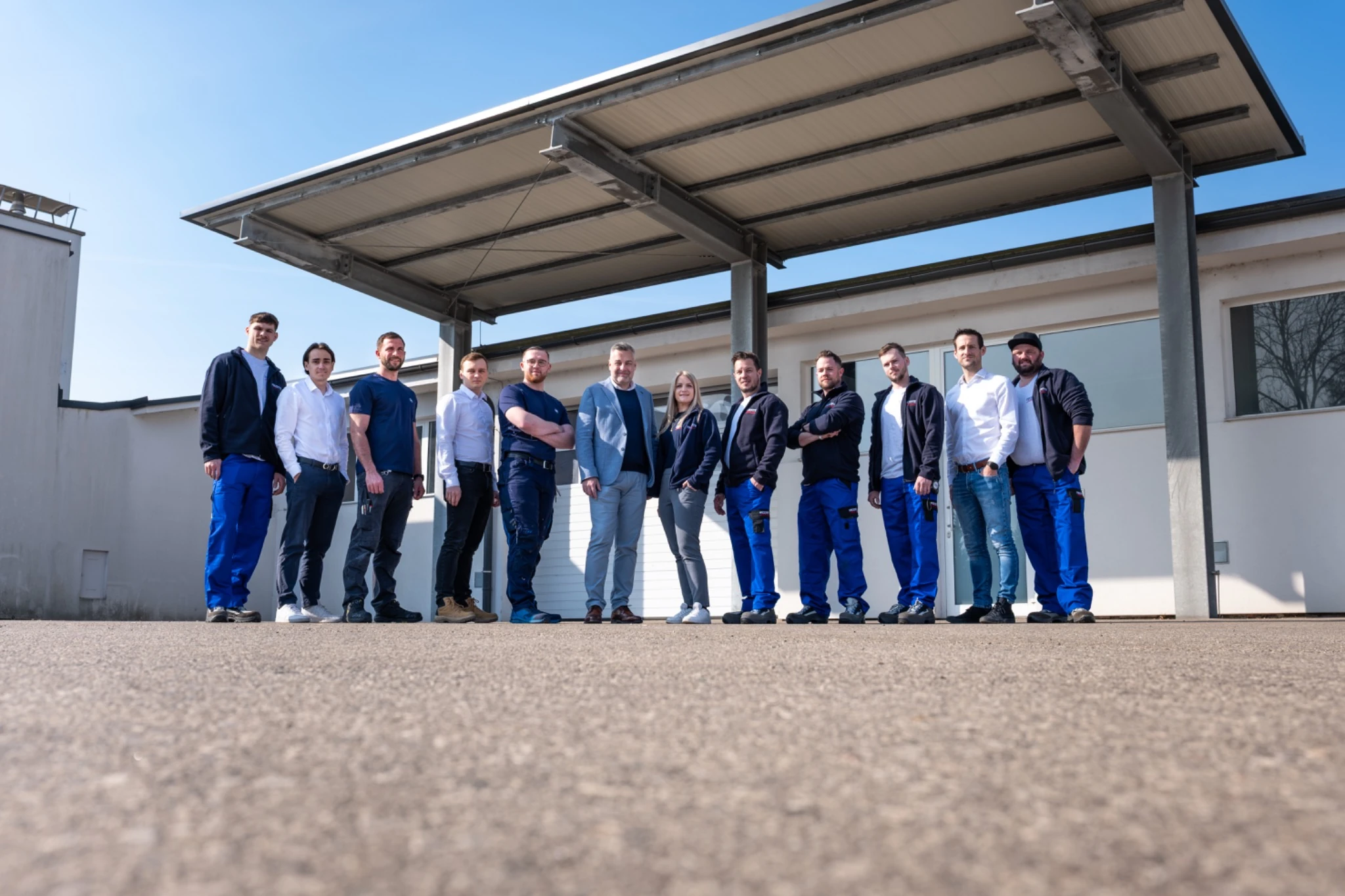 Gesamtes Franye Team für Klimatechnik, Kälte und Sanitär vor Firmengebäude