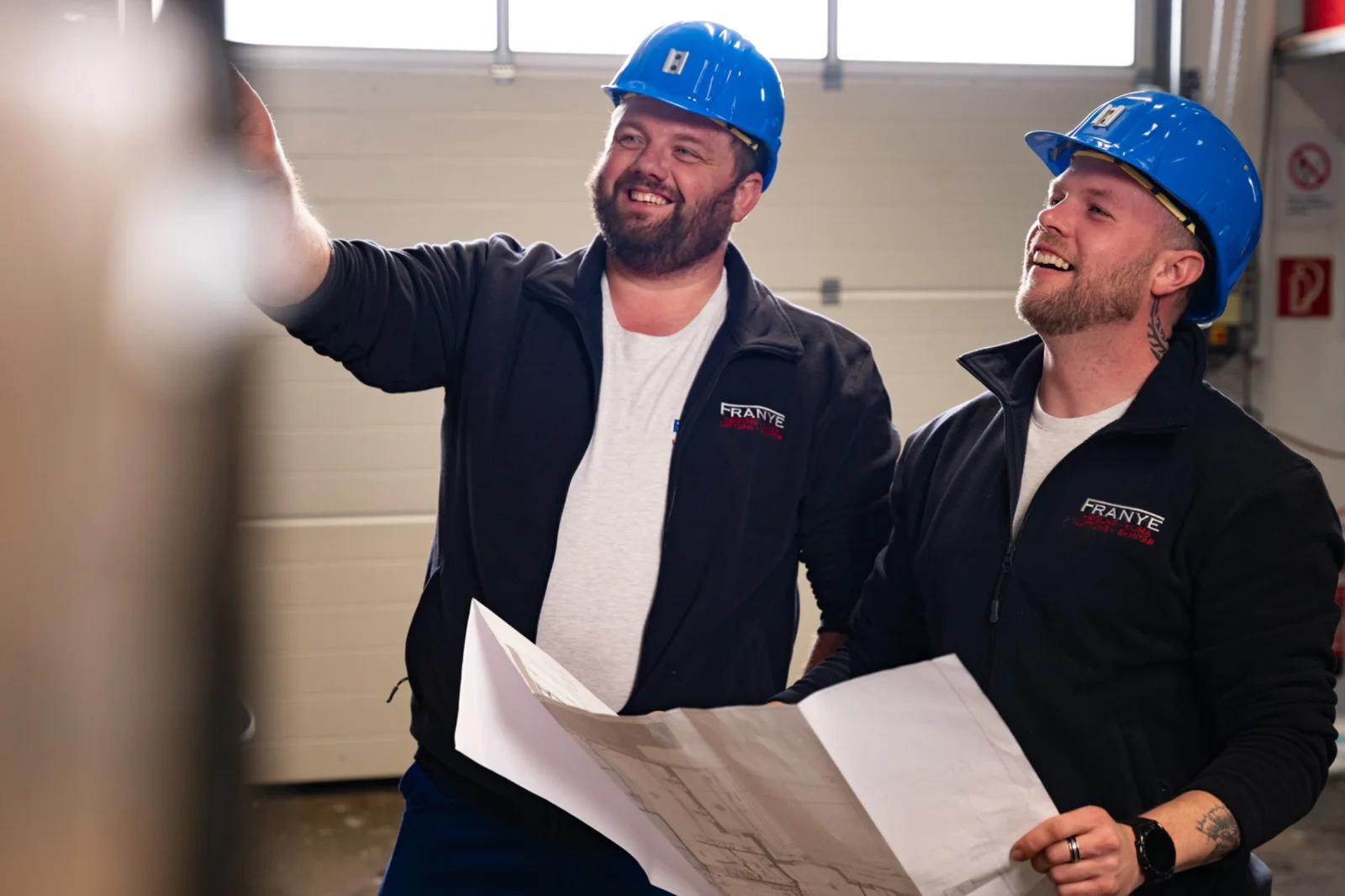 Techniker analysieren Bauplan im Bereich Gebäudetechnik